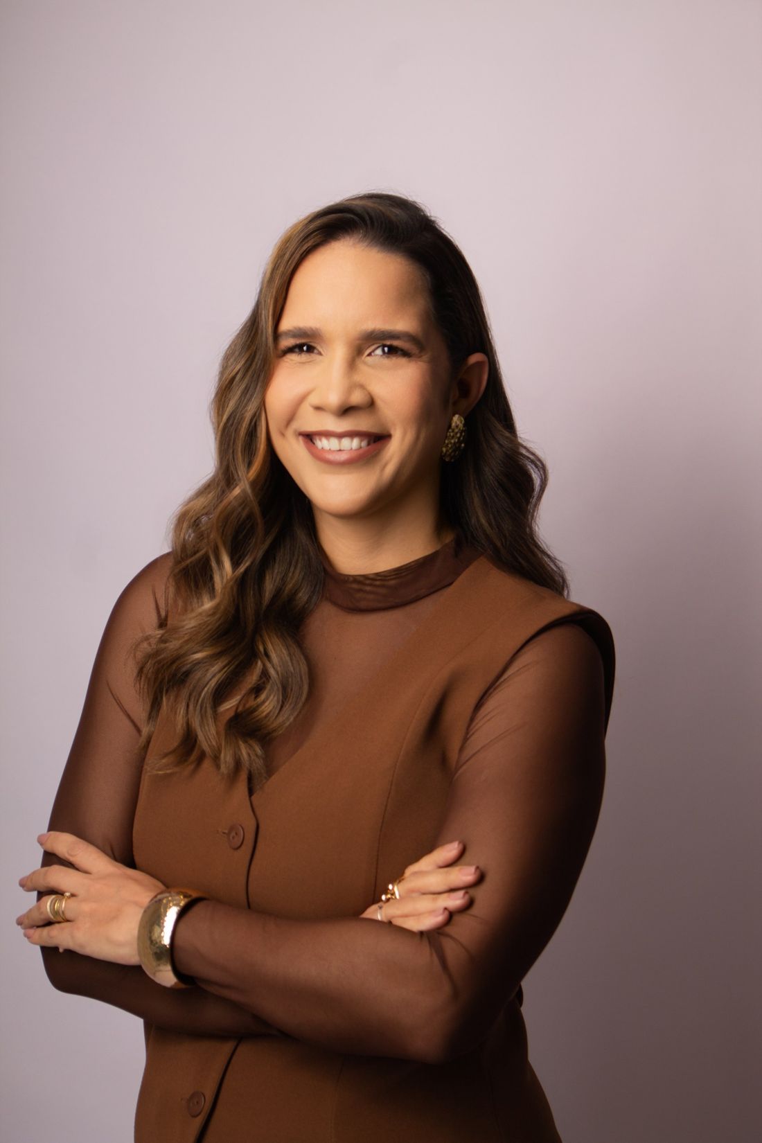 Dra. Dannieli Espirito Santo, nutricionista, de braços cruzados e sorrindo levemente