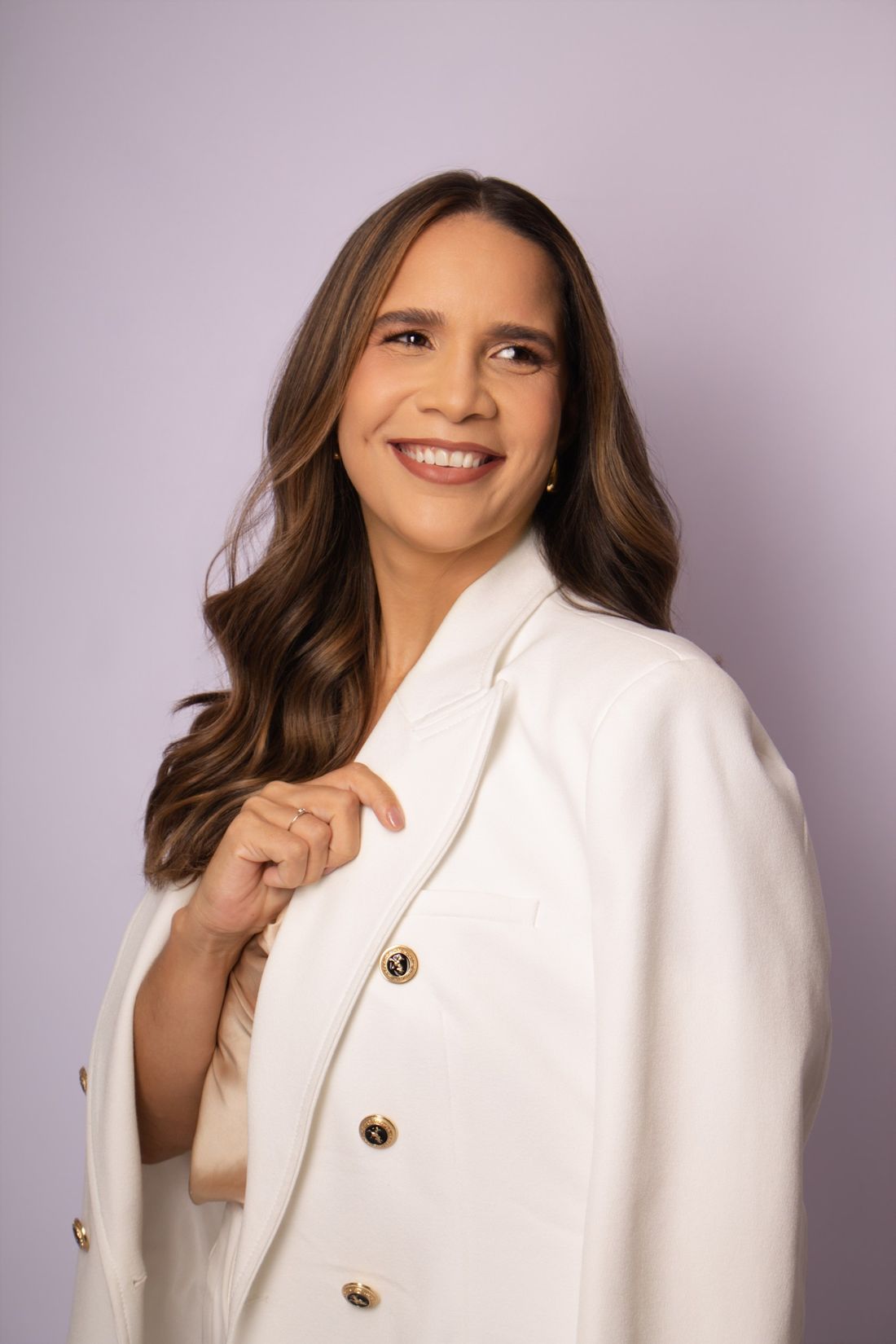 Dra. Dannieli de blazer off-white, olhando para o lado